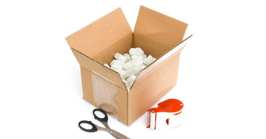 A collection of shipping supplies, including boxes, tape, and packing materials, arranged on a white background.